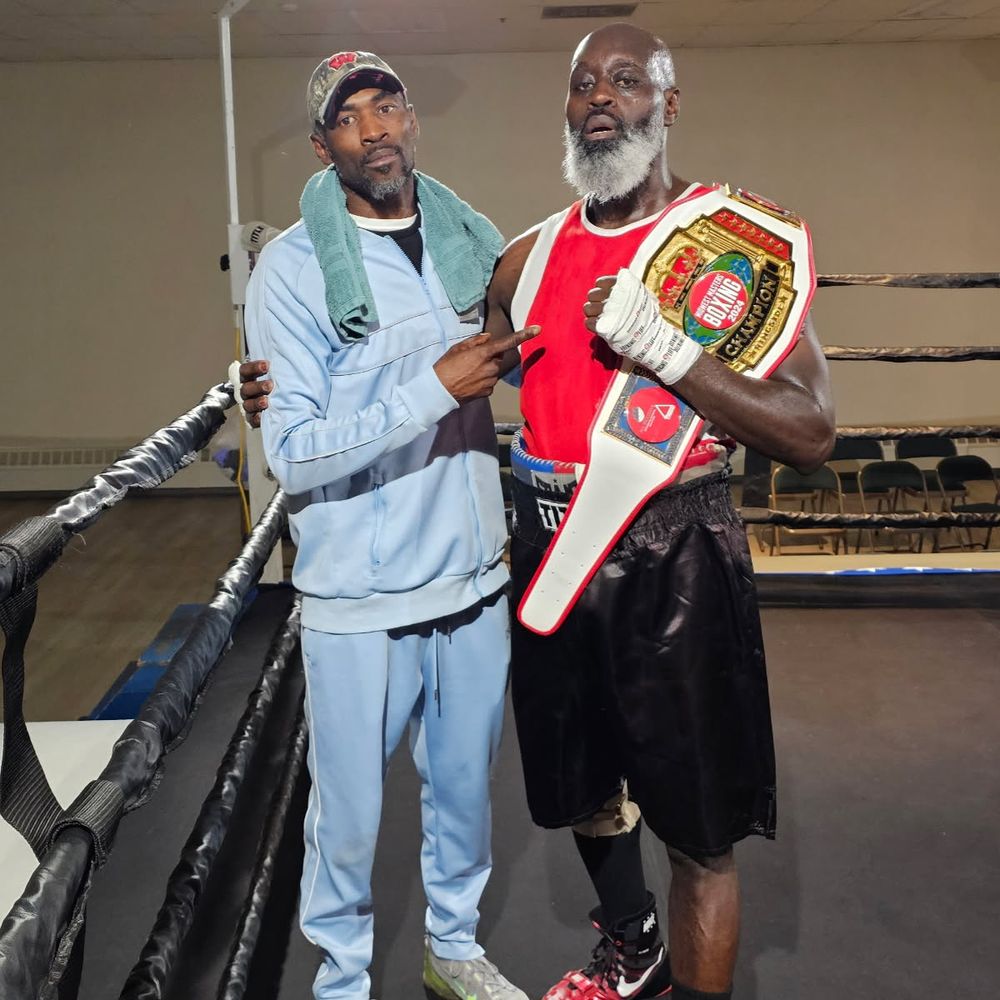 A TOS boxer with his championship belt and coach
