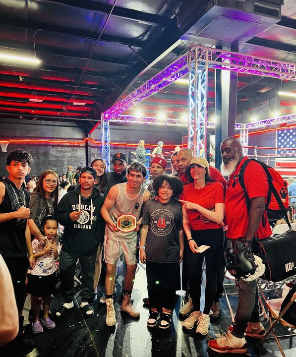 TOS boxer with championship belt, family in the corner