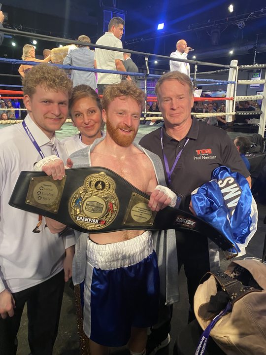 Red-bearded TOS boxer with championship belt, Coach Paul Newman in the corner