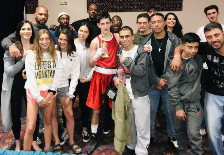 TOS youth boxer with tournament trophy and team