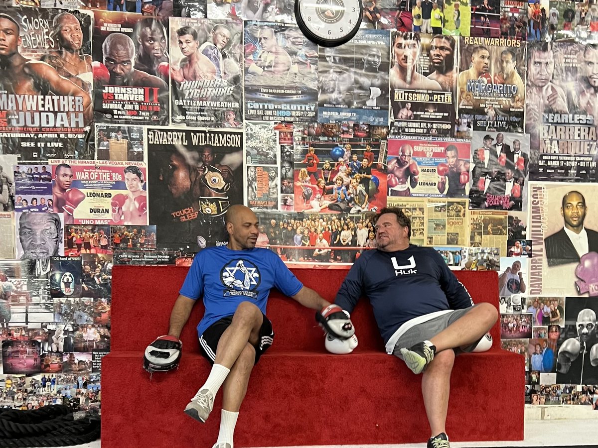 DaVarryl and a longtime private client on the red couch in front of the TOS memory wall